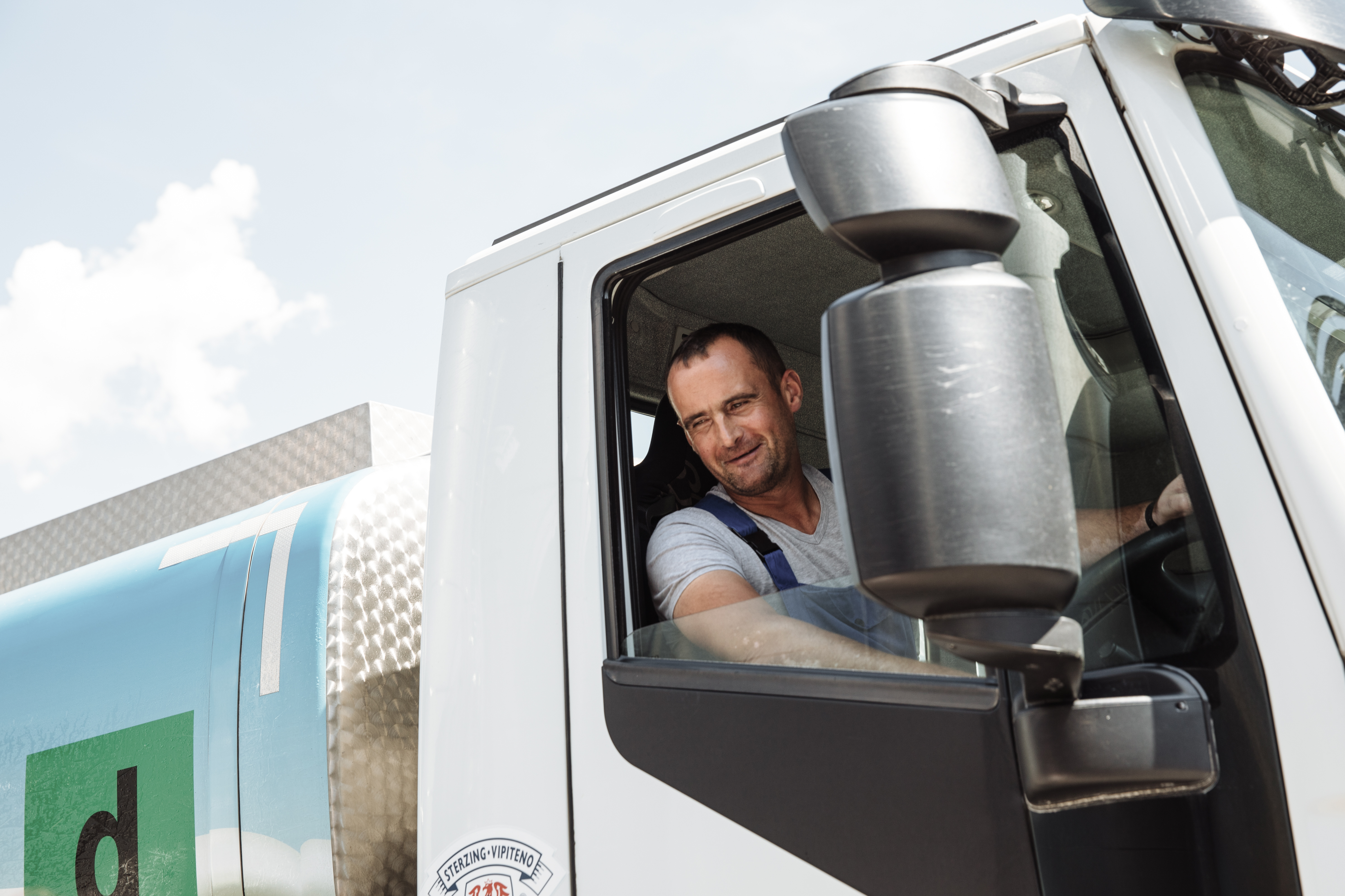 LKW-Fahrer sitzt in der Kabine eines Milchwagens von Milchhof Sterzing und blickt aus dem Fenster