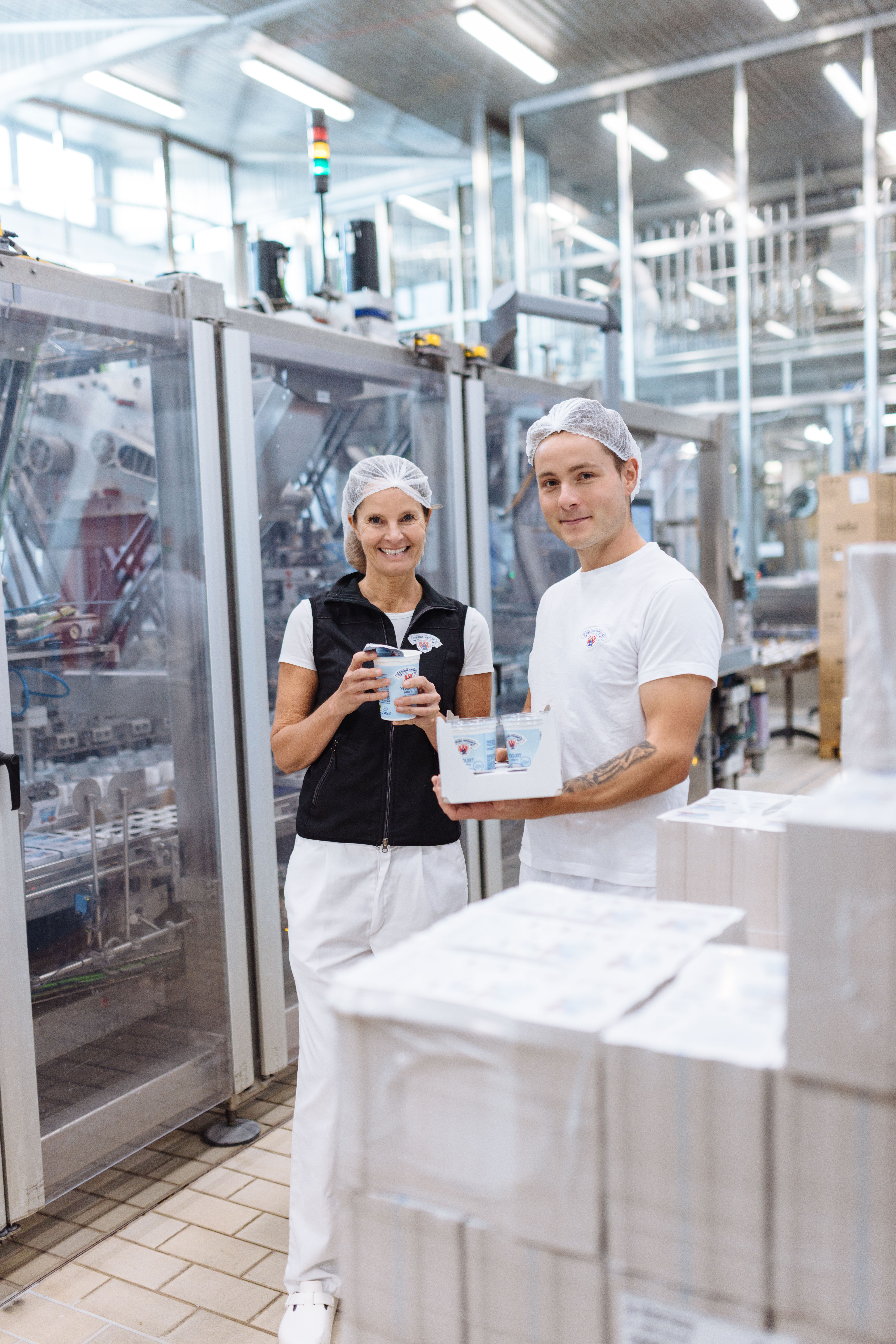 zwie Joghurtmitarbeiter stehen in der Produktion