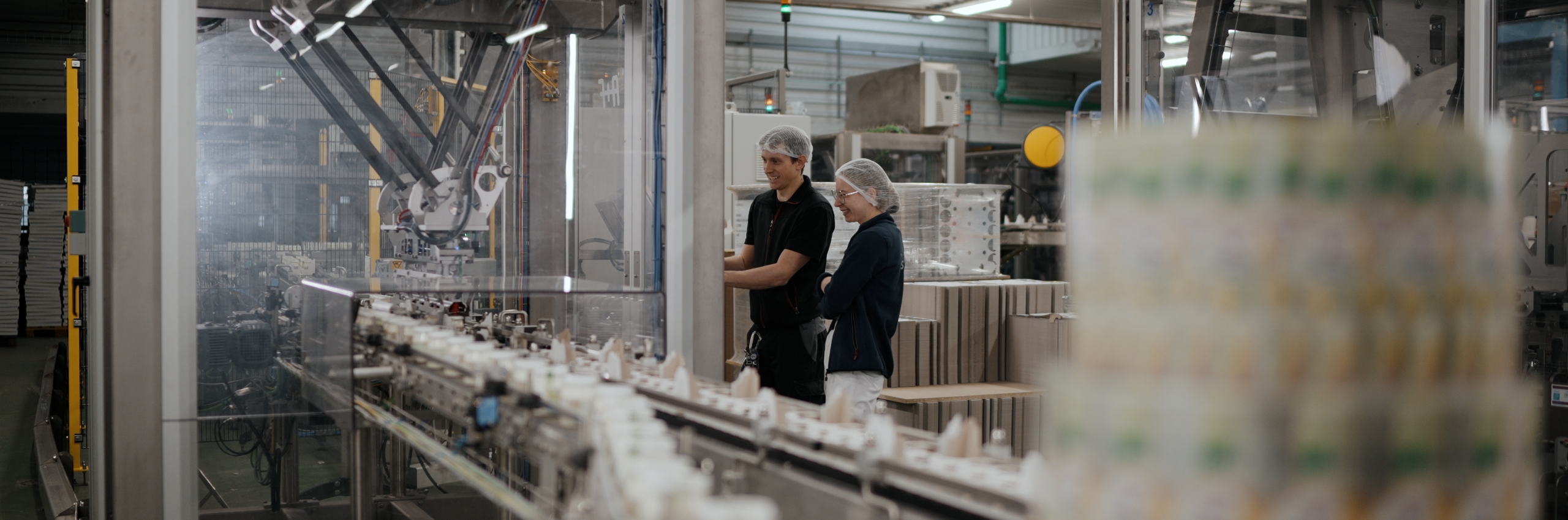Mitarbeitende des Milchhof Sterzing in der modernen Produktionshalle an der Abfüllanlage.
